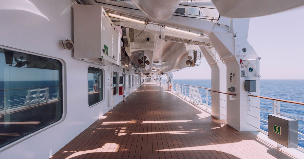 Spacious cruise ship deck overlooking the serene ocean under a clear sky.